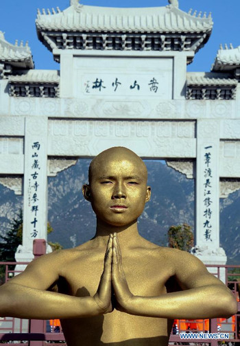 Một võ sinh Thiếu Lâm được thoa lớp sơn màu vàng trông giống như bức tượng đồng.