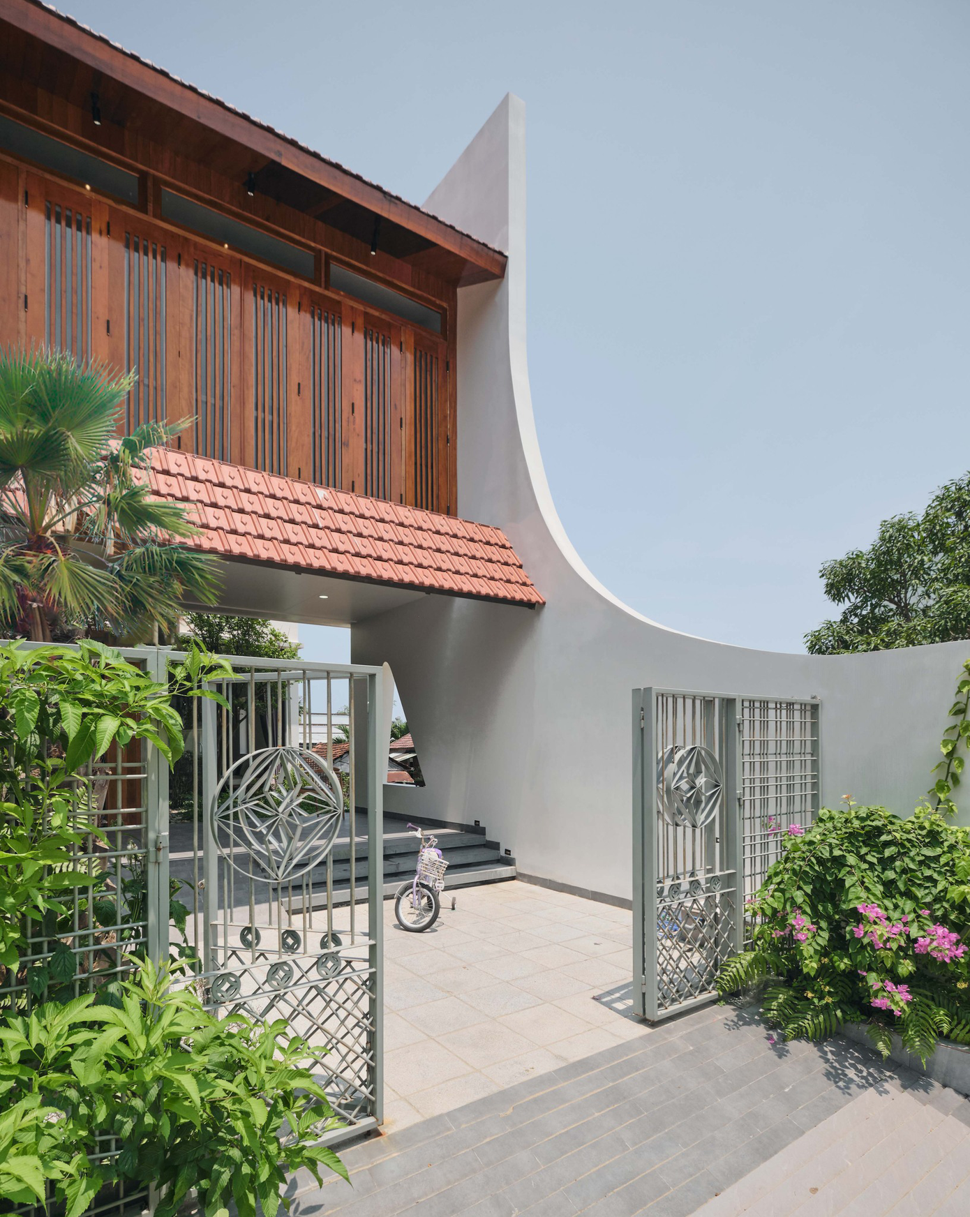 Là sự giao thoa giữa truyền thống và hiện đại, mặt tiền của ngôi nhà gây ấn tượng bởi những đường cong cách điệu mềm mại, duyên dáng. Nếp mái Á Đông cùng hệ cửa gỗ của khối nhà tầng 2 được phát triển dựa trên kiến trúc mang âm hưởng Hội An vừa hiện đại nhưng vẫn toát lên nét hoài cổ và đầy chất tự sự. Là sự giao thoa giữa truyền thống và hiện đại, mặt tiền của ngôi nhà gây ấn tượng bởi những đường cong cách điệu mềm mại, duyên dáng. Nếp mái Á Đông cùng hệ cửa gỗ của khối nhà tầng 2 được phát triển dựa trên kiến trúc mang âm hưởng Hội An vừa hiện đại nhưng vẫn toát lên nét hoài cổ và đầy chất tự sự.