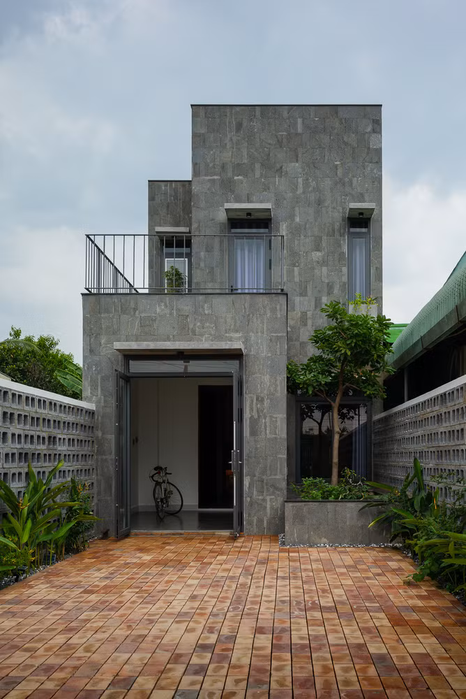 Kiến trúc sư sử dụng đá tự nhiên, khối bê tông và gạch thô để làm mặt tiền tạo sự đơn giản và gần gũi, không bị quá nổi bật so với những ngôi nhà xung quanh. Kiến trúc sư sử dụng đá tự nhiên, khối bê tông và gạch thô để làm mặt tiền tạo sự đơn giản và gần gũi, không bị quá nổi bật so với những ngôi nhà xung quanh.