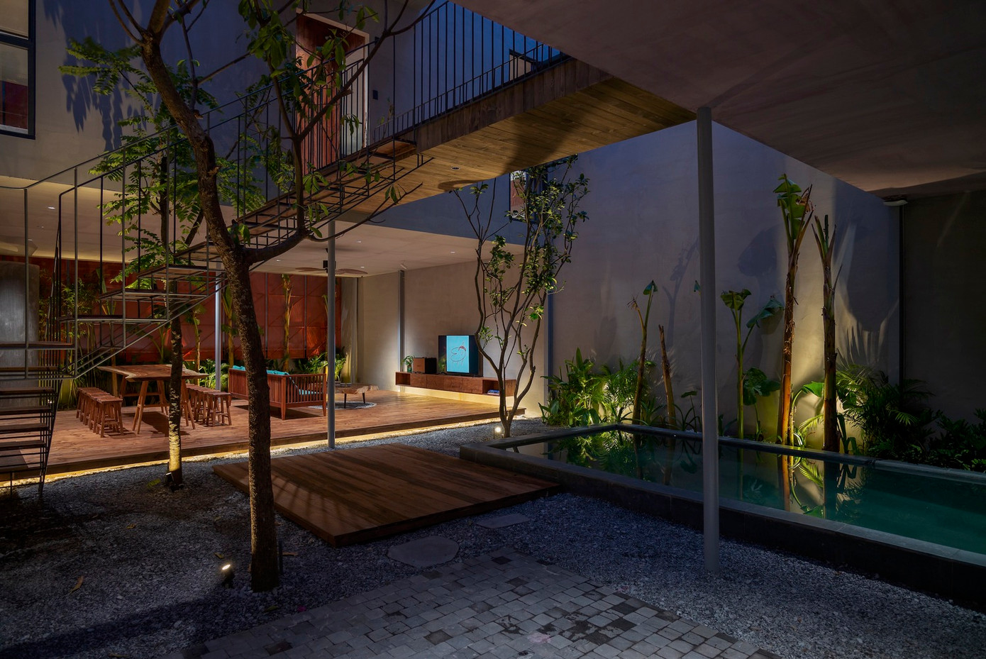 Tại tầng 1, các không gian chức năng được lát sàn gỗ tự nhiên, đá tự nhiên địa phương xen kẽ cây xanh tạo cảm giác trong và ngoài ngôi nhà như ngôi nhà thứ hai vô cùng gần gũi.