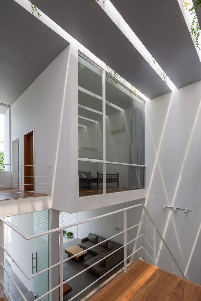 Điểm nhấn của ngôi nhà là khoảng giếng trời tràn ngập ánh sáng tự nhiên giúp đối lưu không khí, bên cạnh đó là cây xanh trên mái rủ xuống giếng trời như một khu vườn treo nhỏ.