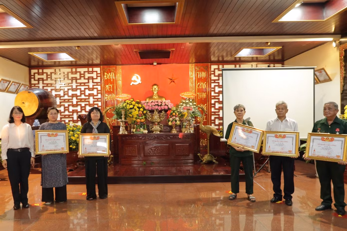 Đại diện CLB Truyền thống kháng chiến Khối phụ nữ TPHCM nhận bằng "Tổ quốc ghi công" cho 5 liệt sĩ Tiểu đoàn nữ biệt động Lê Thị Riêng. Ảnh: Phạm Thương