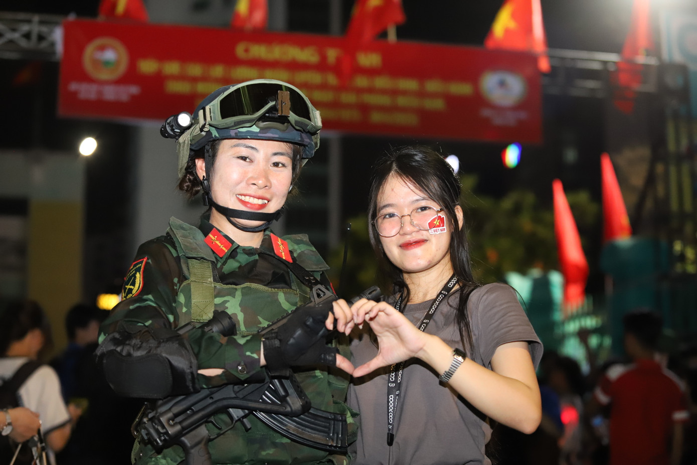 Bạn trẻ chụp hình lưu niệm cùng các khối tham gia diễu binh, diễu hành.