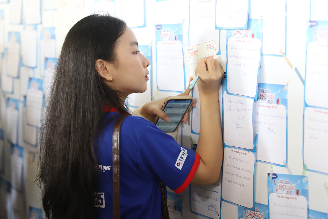 Một bạn tình nguyện viên chương trình Tiếp sức mùa thi viết lời chúc gửi đến các sĩ tử trước kỳ thi. Kỳ thi tốt nghiệp THPT năm 2025 sẽ diễn ra từ ngày 25-28/6/2025. Ảnh: Ngô Tùng