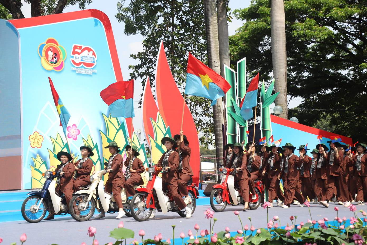 Các bạn thiếu nhi tái hiện lực lượng nữ biệt động đang di chuyển bằng xe máy trên đường phố Sài Gòn ngày 30/4/1975 để dẫn đường cho các đoàn quân giải phóng đang rầm rập tiến về giải phóng. Giữa lòng đô thị sôi sục, những nữ biệt động gan dạ không chỉ tham gia chiến đấu, mà còn làm nhiệm vụ trinh sát, liên lạc, dẫn đường cho các cánh quân tiến vào những mục tiêu quan trọng.