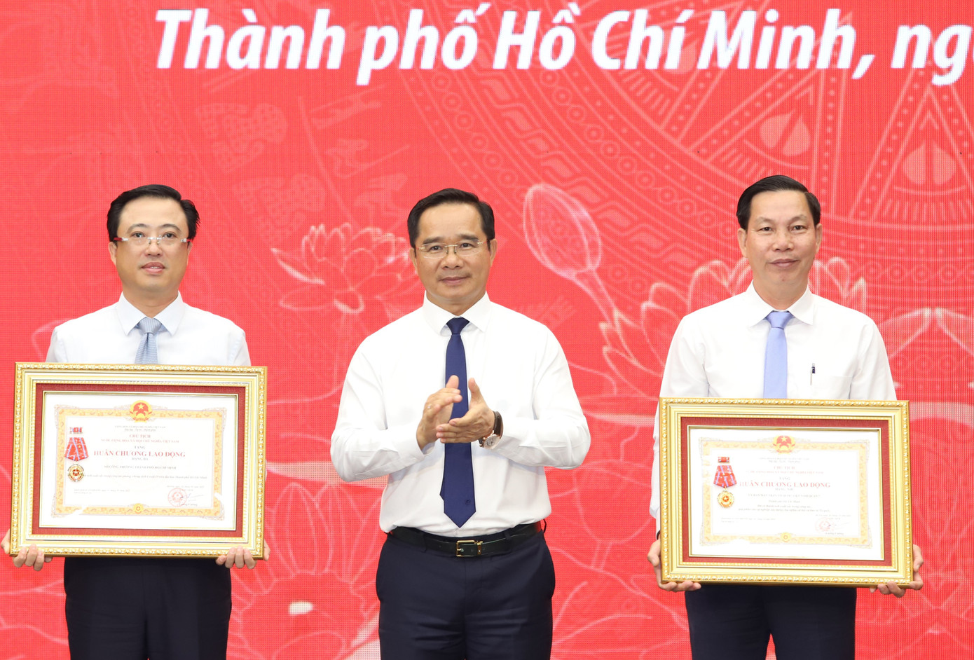 Chủ tịch UBND TPHCM trao Huân chương Lao động của Chủ tịch nước cho đại diện Ủy ban MTTQ Việt Nam quận 7 và Sở Công Thương TPHCM. Ảnh: Ngô Tùng.