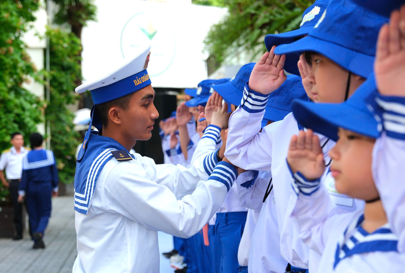 Các em thiếu nhi được chiến sĩ Hải quân hướng dẫn nghi thức chào điều lệnh tại buổi xuất quân.
