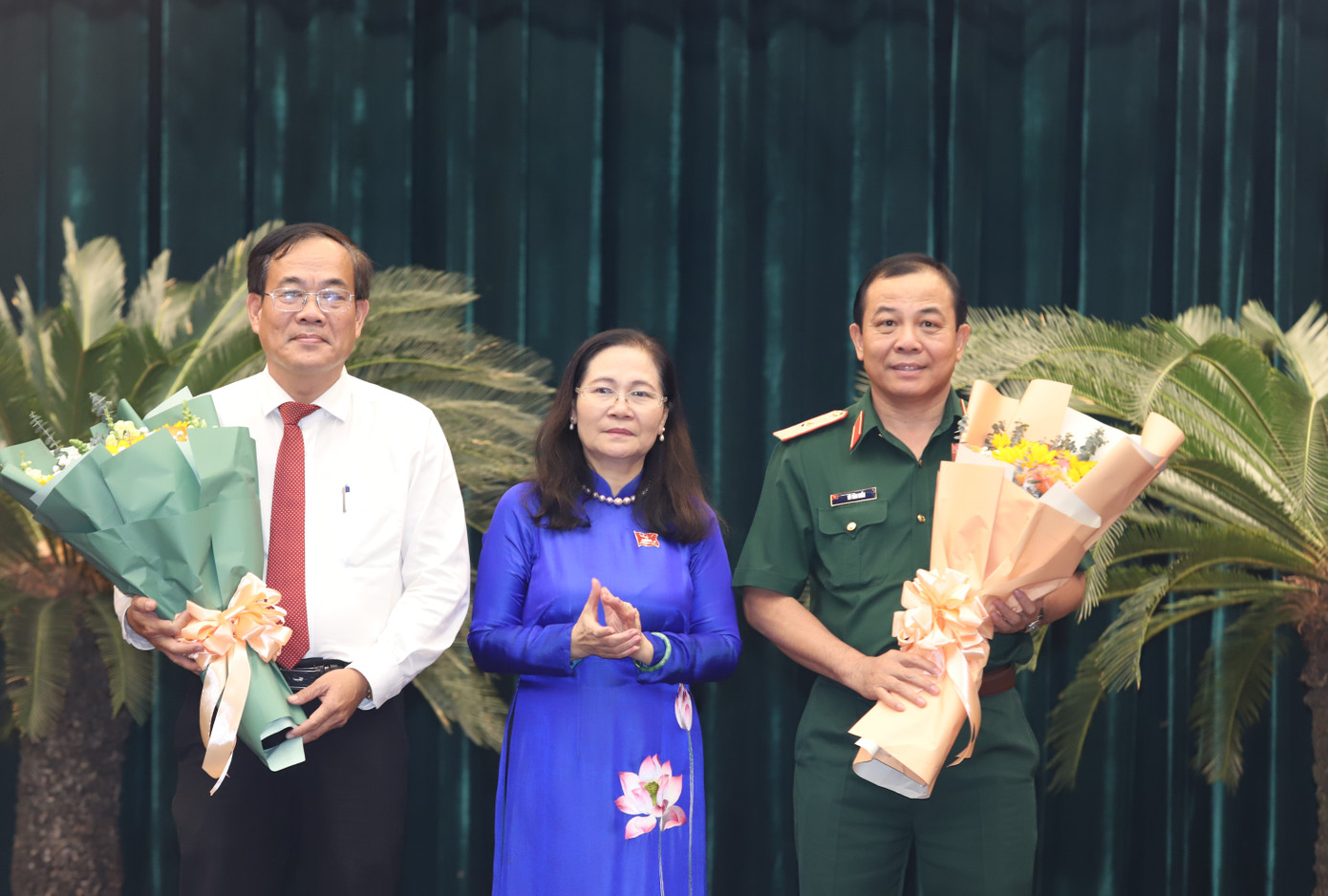 Chủ tịch HĐND TPHCM Nguyễn Thị Lệ trao hoa chúc mừng hai tân Ủy viên UBND TPHCM: Thiếu tướng Vũ Văn Điền và ông Nguyễn Duy Tân (bên trái). Ảnh: Ngô Tùng