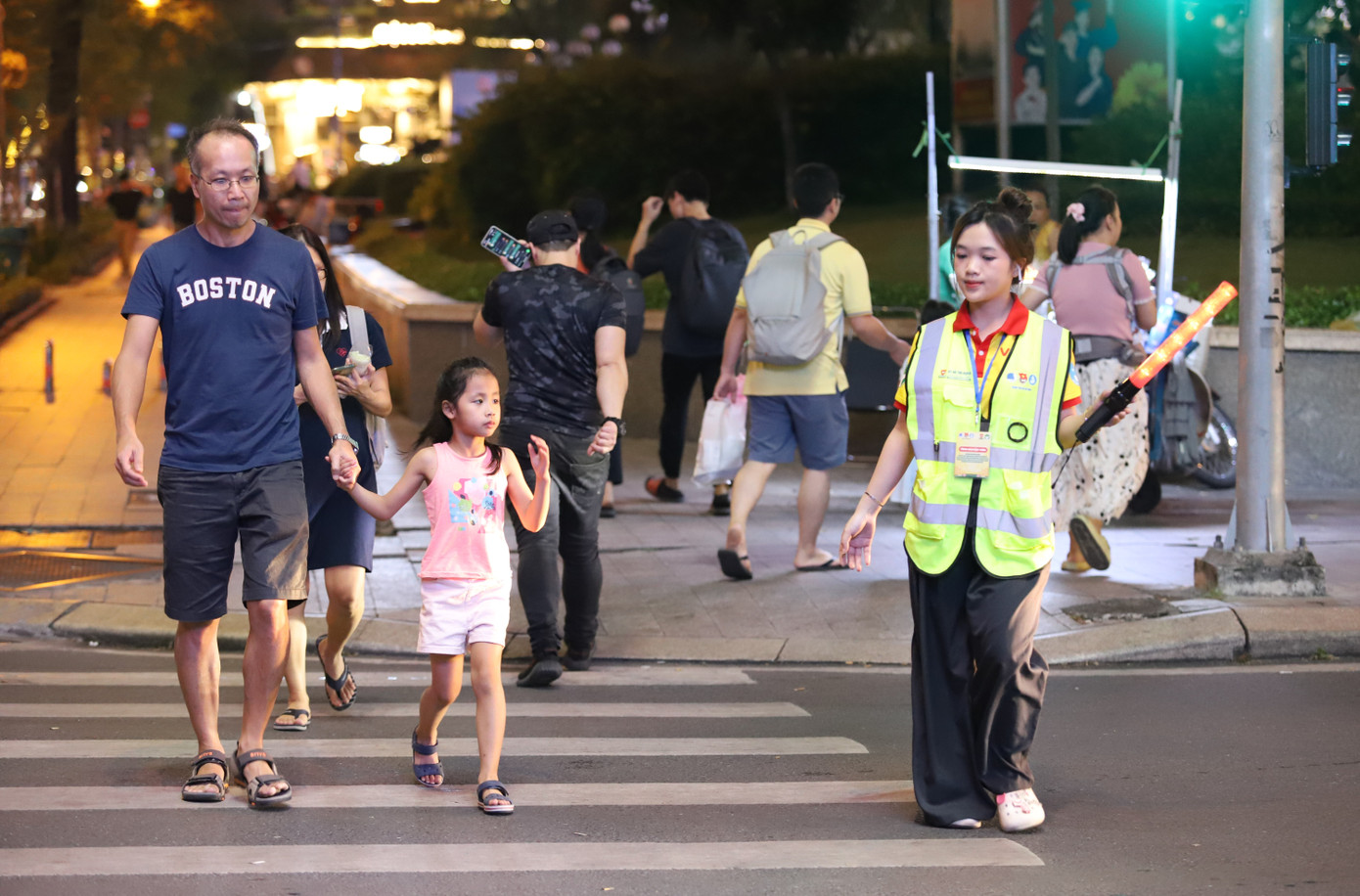 Nữ chiến sĩ tình nguyện chiến dịch Xuân tình nguyện giúp một em bé cùng người thân qua đường.