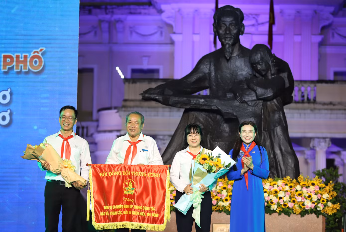 Chị Nguyễn Phạm Duy Trang trao cờ của Hội đồng Đội Trung ương ghi nhận những đóng góp tích cực của Nhà Thiếu nhi TPHCM.