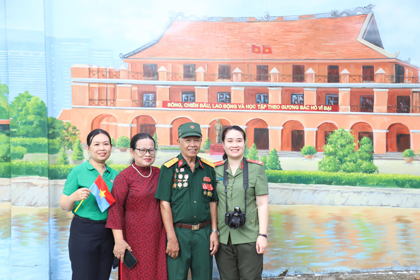 Các đại biểu, khách mời bên khung bích họa về Bảo tàng Hồ Chí Minh - Chi nhánh TPHCM.