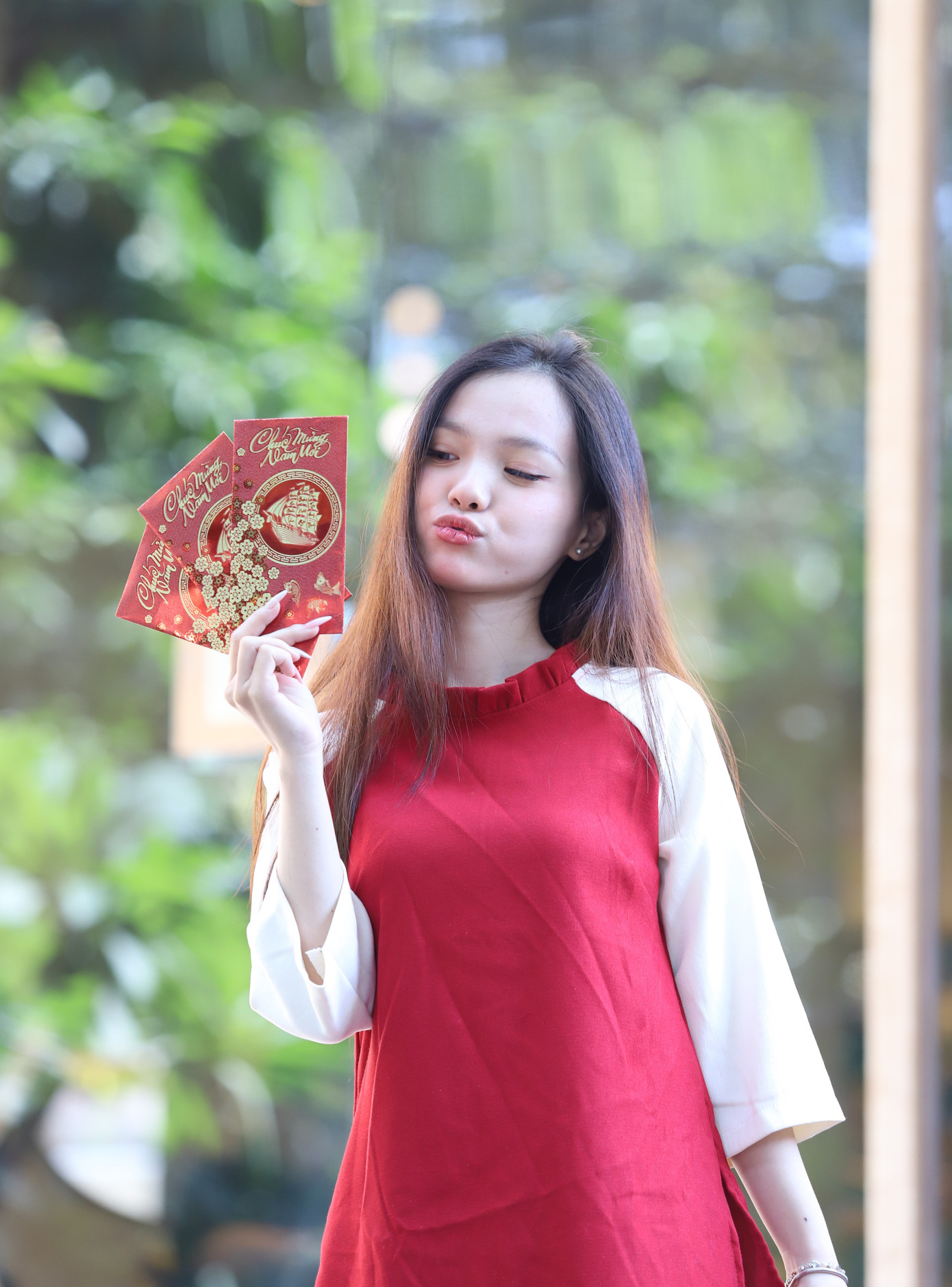 Tranh thủ ngày nghỉ, Ngọc Anh cùng nhóm bạn hẹn nhau chụp hình với bộ áo dài truyền thống đi kèm những phụ kiện đặc trưng ngày Tết như bao lì xì, cành hoa tuyết mai.