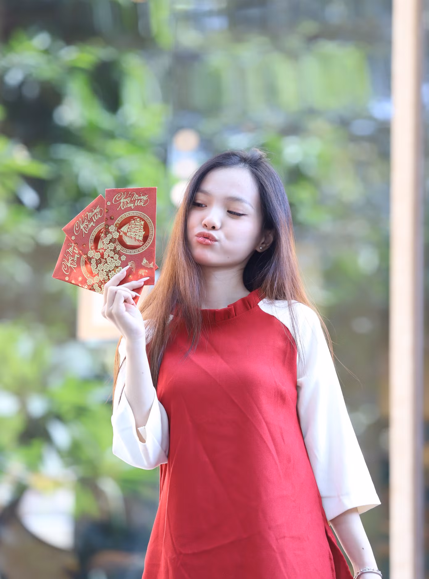 Tranh thủ ngày nghỉ, Ngọc Anh cùng nhóm bạn hẹn nhau chụp hình với bộ áo dài truyền thống đi kèm những phụ kiện đặc trưng ngày Tết như bao lì xì, cành hoa tuyết mai.