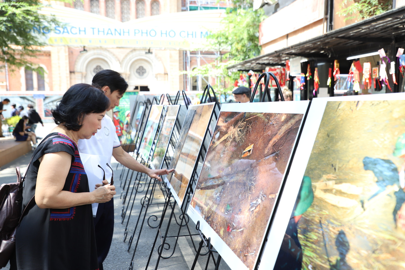 Người dân, du khách lặng nhìn những bức ảnh về Làng Nủ. Tác giả Nguyễn Á cho biết, toàn bộ kinh phí từ bán sách ảnh sẽ dành ủng hộ cho bà con thôn Làng Nủ. Ảnh: Ngô Tùng