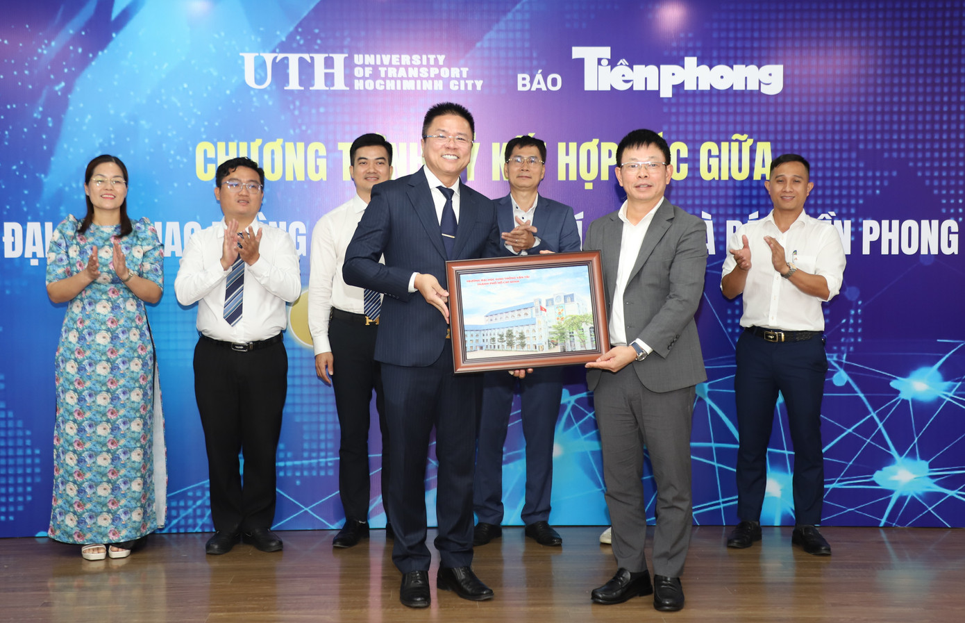 Lãnh đạo UTH và báo Tiền Phong trao quà kỷ niệm tại buổi ký kết.