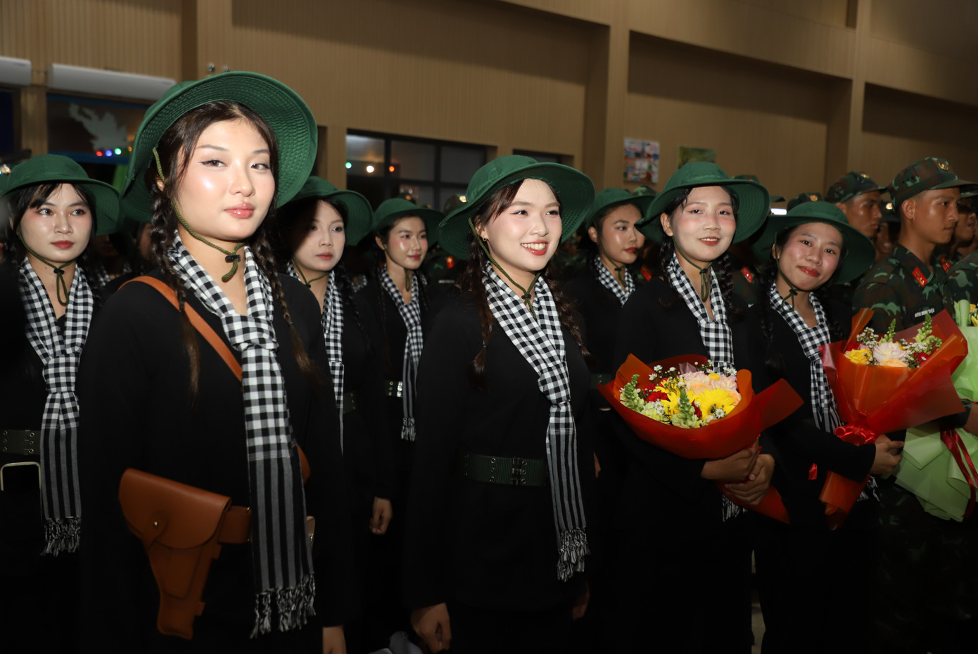 Các cô gái khối Nữ du kích miền Nam trong trang phục áo bà ba, mũ tai bèo và quàng khăn rằn.