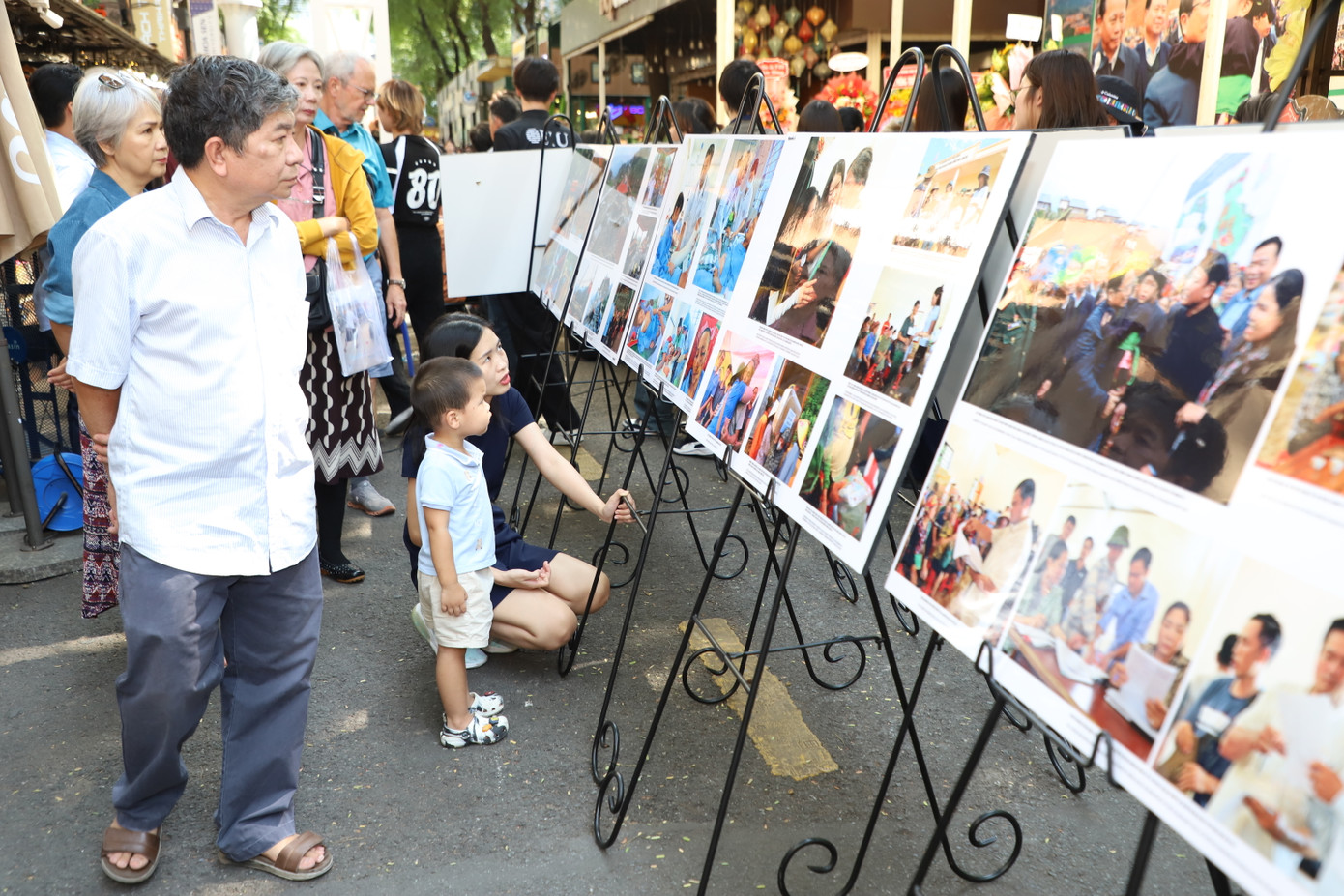 Người dân, du khách lặng nhìn những bức ảnh về Làng Nủ. Tác giả Nguyễn Á cho biết, toàn bộ kinh phí từ bán sách ảnh sẽ dành ủng hộ cho bà con thôn Làng Nủ. Ảnh: Ngô Tùng