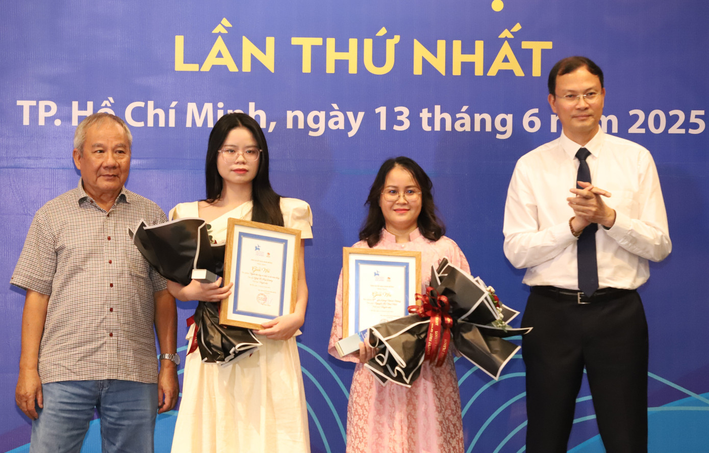 Giám đốc NXB Kim Đồng Bùi Tuấn Nghĩa (phải) cùng nhà văn Trần Đức Tiến trao giải Nhì cho hai nữ tác giả.