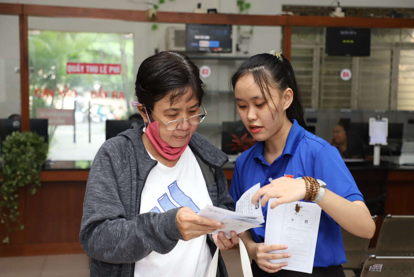 Tuyết Ngân hướng dẫn một người dân lớn tuổi.