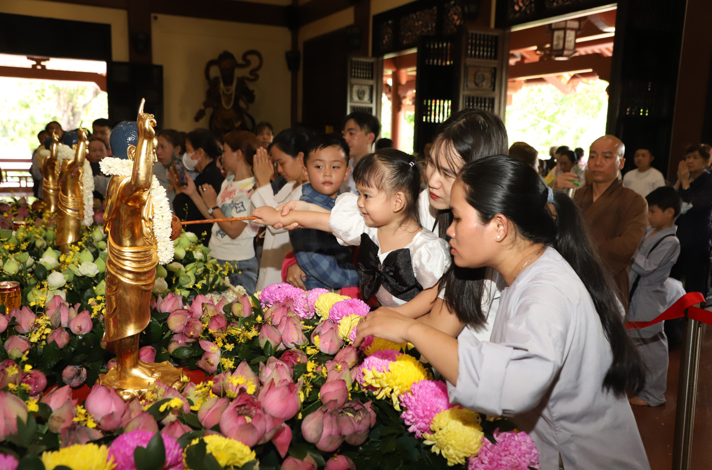 Tại chánh điện chùa Huệ Nghiêm, bà con nhân dân xếp hàng và tuần tự thực hiện nghi lễ Mộc dục (tắm Phật).