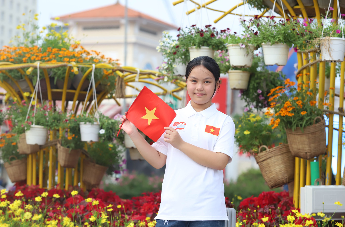 Bé Muội (con gái chị Hiệp) tranh thủ check-in trong vườn hoa trước khu vực nhà ga Bến Thành, quận 1.