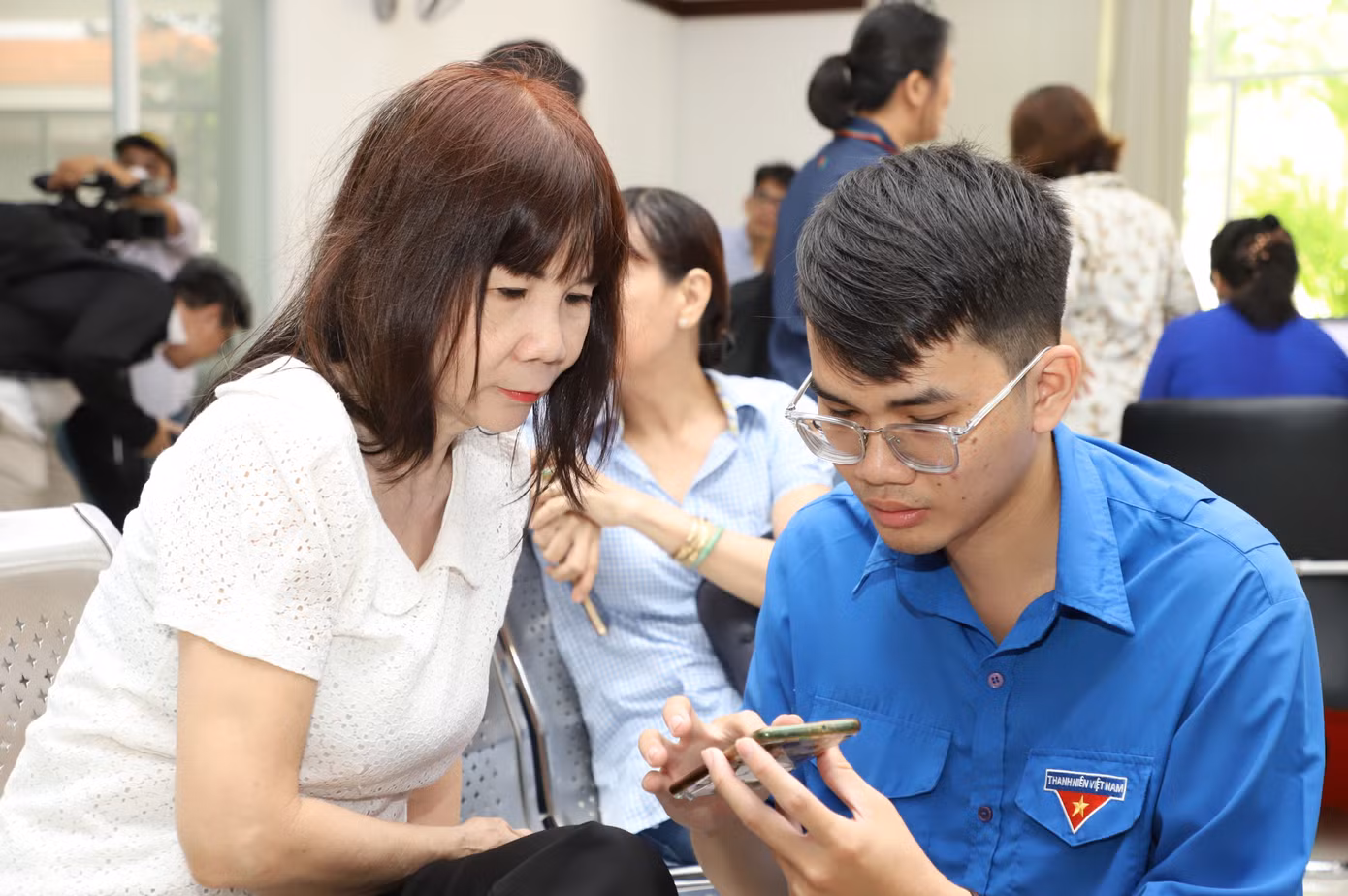 Bạn trẻ hướng dẫn người dân thực hiện các thủ tục hành chính đơn giản trên môi trường số.