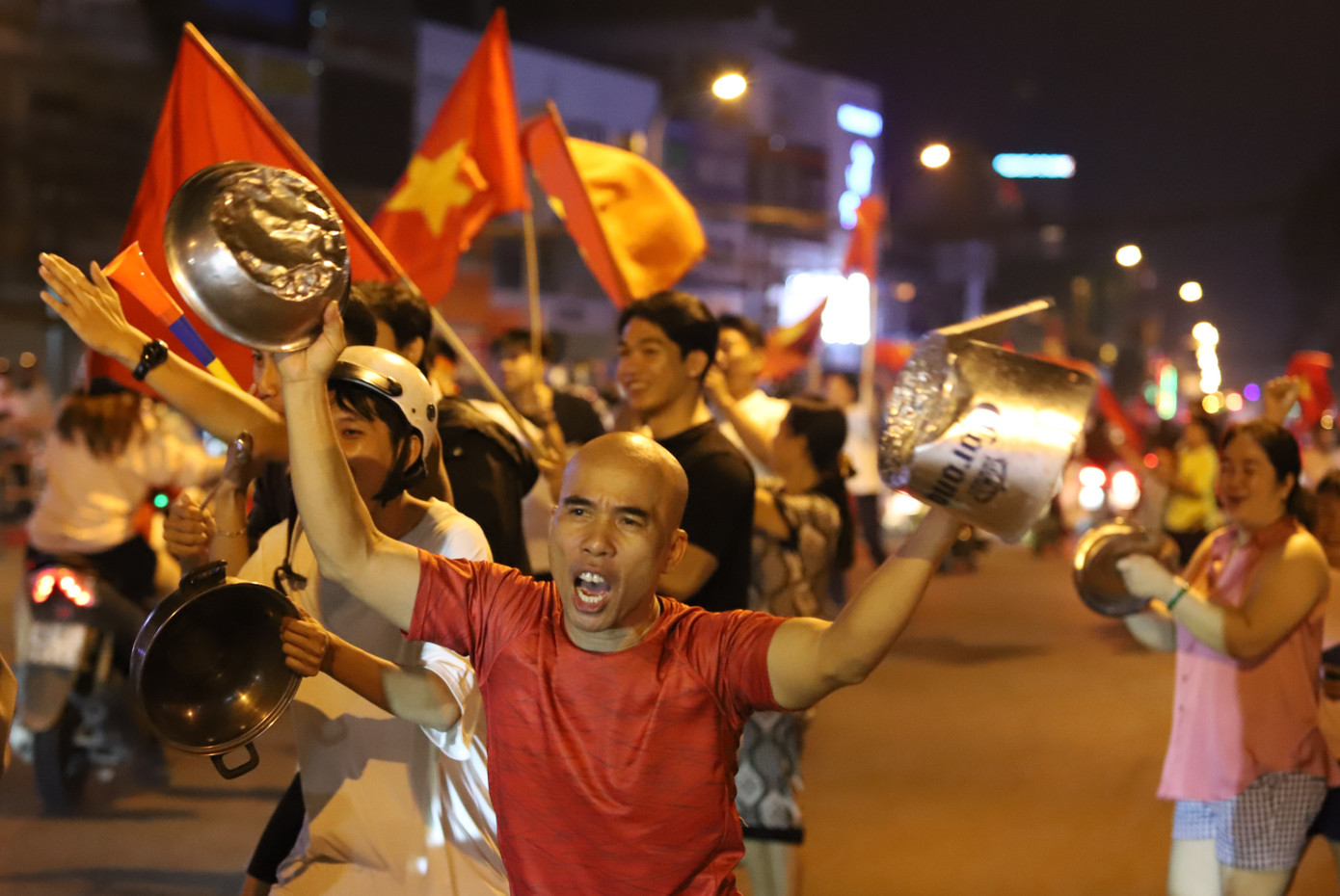 Mọi người mang những vật dụng gia đình ra đường ăn mừng.