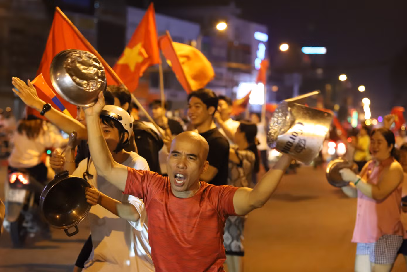 Mọi người mang những vật dụng gia đình ra đường ăn mừng.