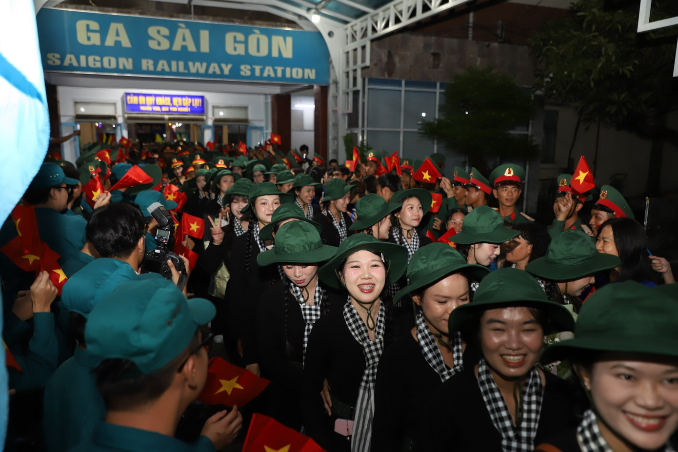 Các cô gái khối Nữ du kích miền Nam trong trang phục áo bà ba, mũ tai bèo và quàng khăn rằn.