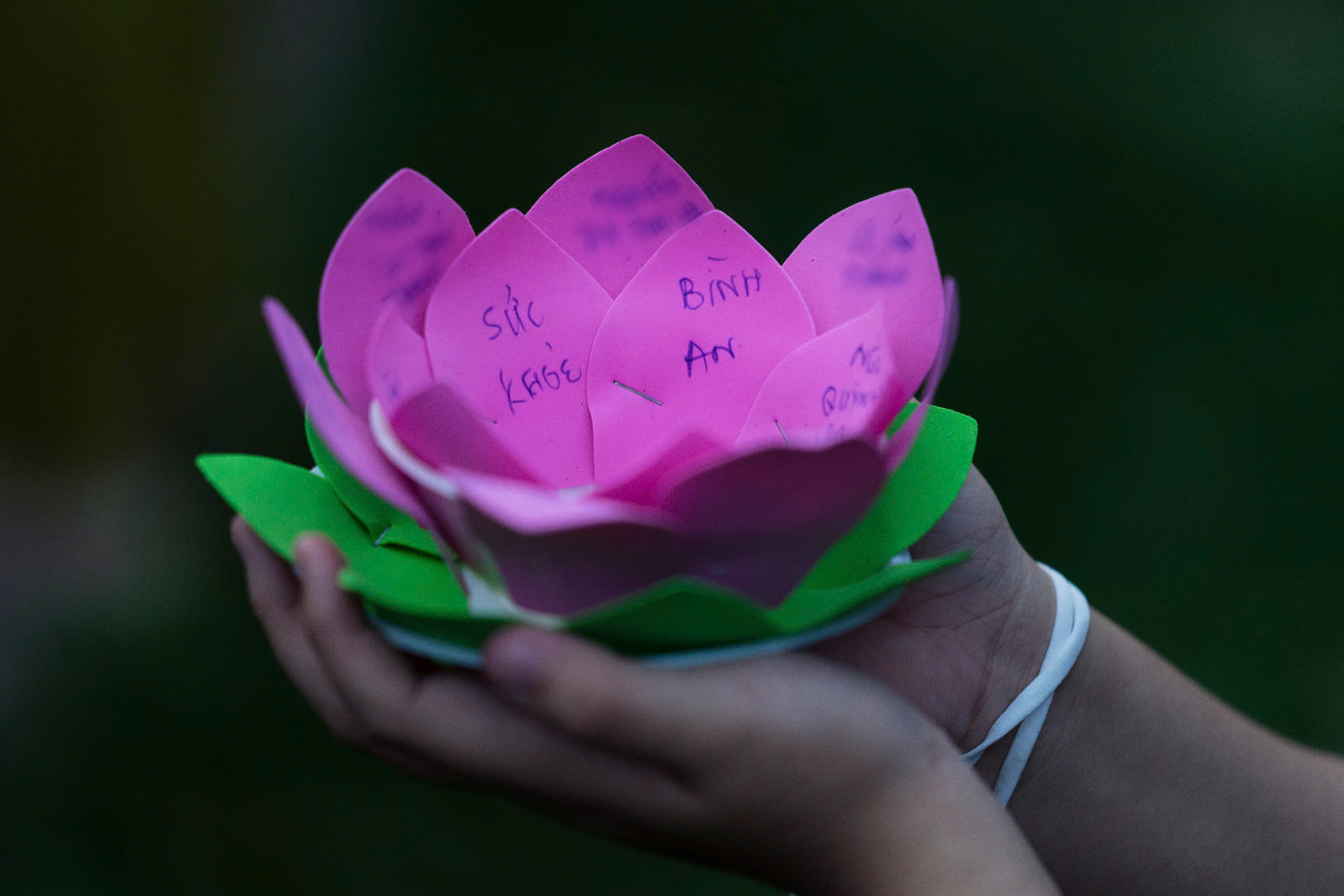 Nhận chiếc đèn hoa, người dân viết lên những lời cầu nguyện tốt đẹp dành cho mình và gia đình để sau đó thả vào dòng kênh Nhiêu Lộc - Thị Nghè, đoạn qua nhà chùa.