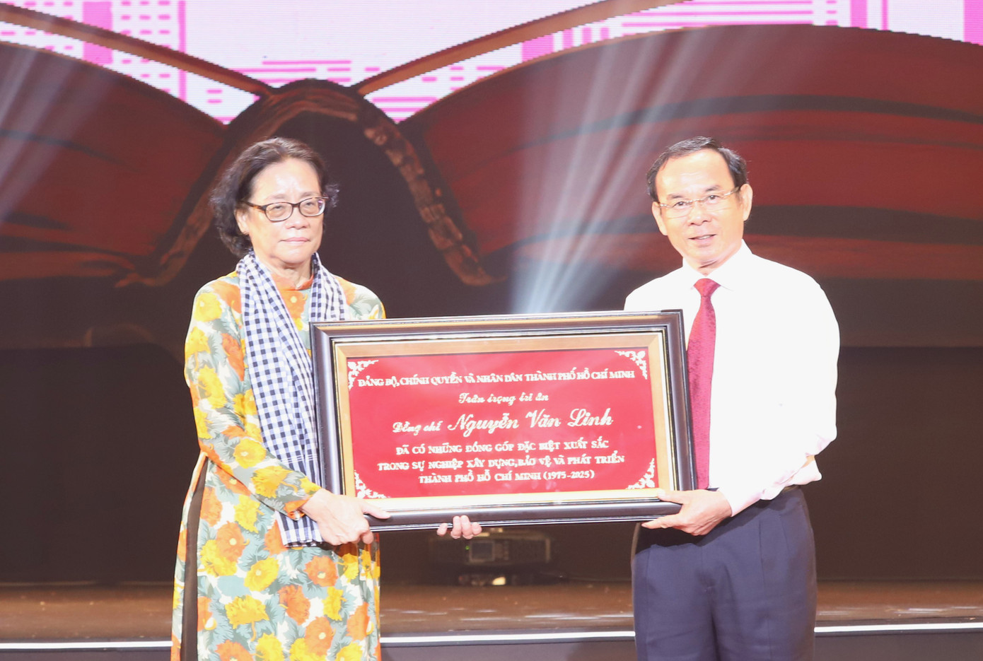 Bí thư Thành ủy TPHCM trao bức khánh tri ân đóng góp tiêu biểu của cố Tổng Bí thư Nguyễn Văn Linh, đến đại diện gia đình cố Tổng Bí thư. Ảnh: Ngô Tùng.