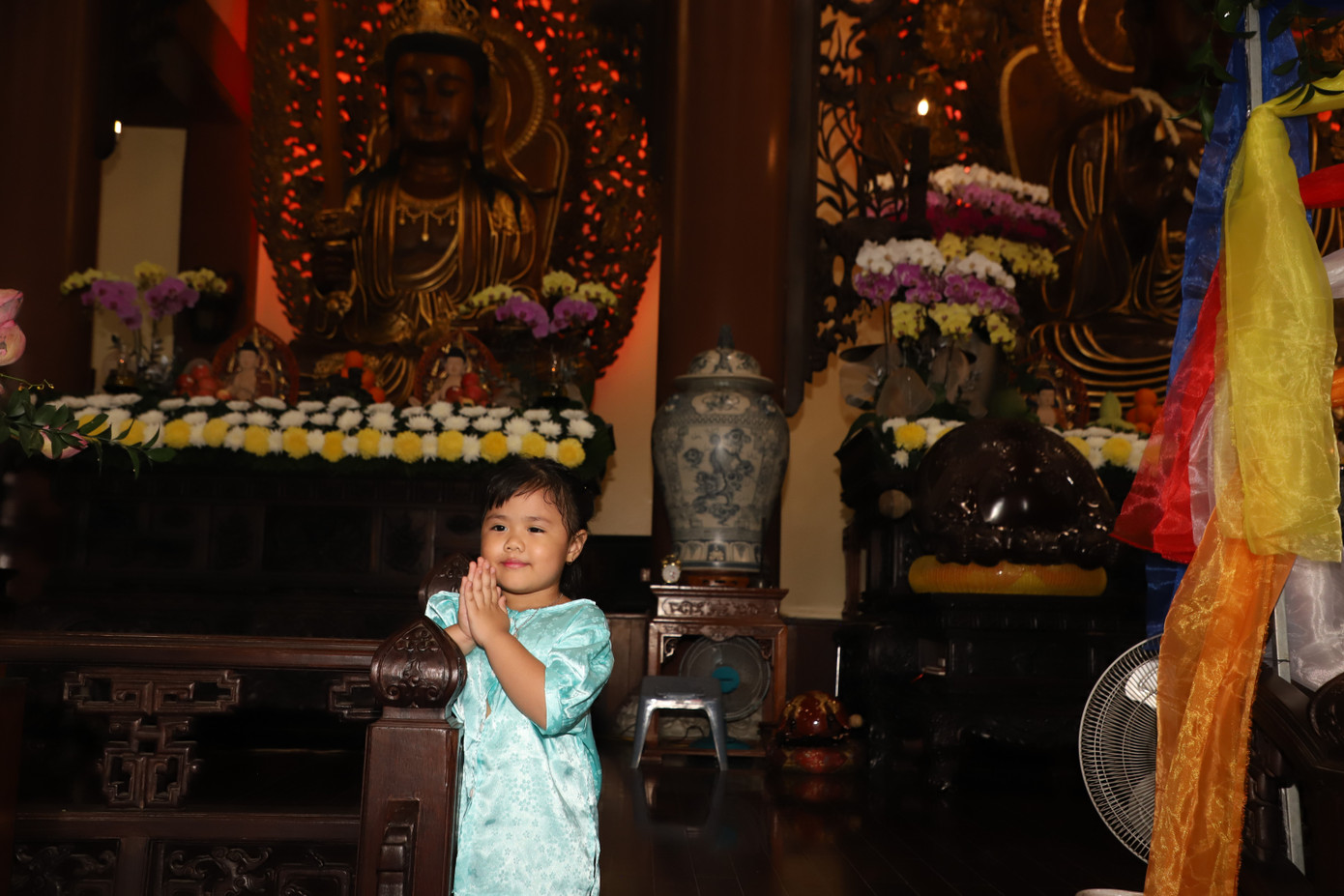 Em bé được người thân hướng dẫn đảnh lễ Phật.