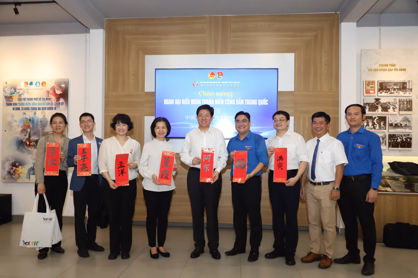 Các đại biểu đón nhận bức thư pháp được họa ngay khi đoàn đến thăm.