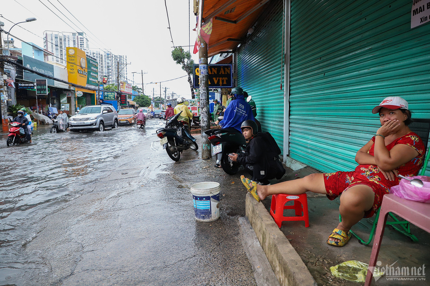 Nhiều người dân dừng chân trên vỉa hè chờ nước rút bớt mới tiếp tục di chuyển.