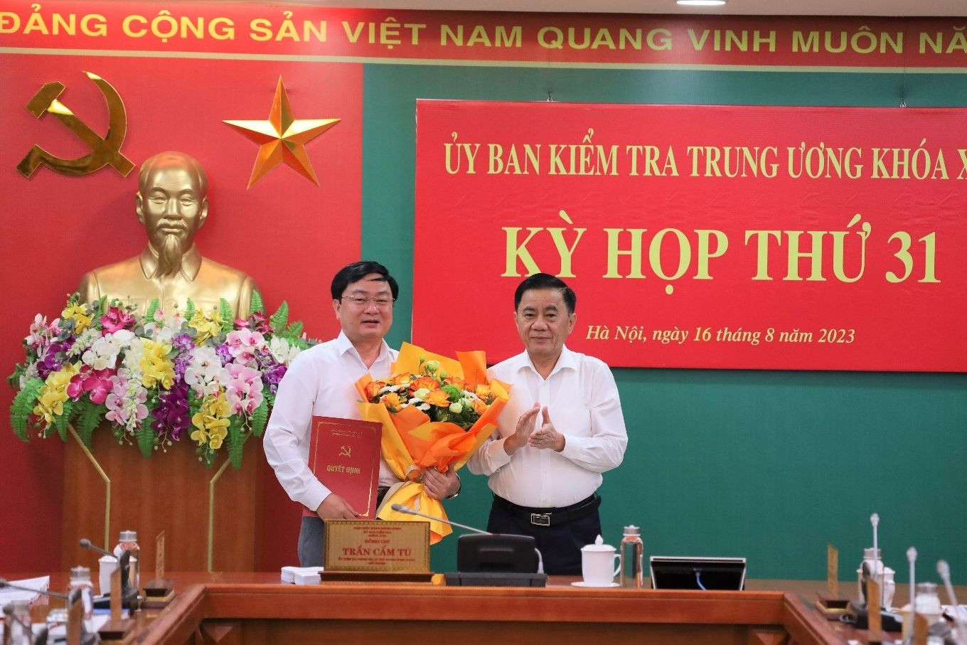 Ông Trần Cẩm Tú, Ủy viên Bộ Chính trị, Bí thư Trung ương Đảng, Chủ nhiệm Ủy ban Kiểm tra Trung ương trao quyết định và tặng hoa chúc mừng ông Nguyễn Văn Quyết. Ông Trần Cẩm Tú, Ủy viên Bộ Chính trị, Bí thư Trung ương Đảng, Chủ nhiệm Ủy ban Kiểm tra Trung ương trao quyết định và tặng hoa chúc mừng ông Nguyễn Văn Quyết.