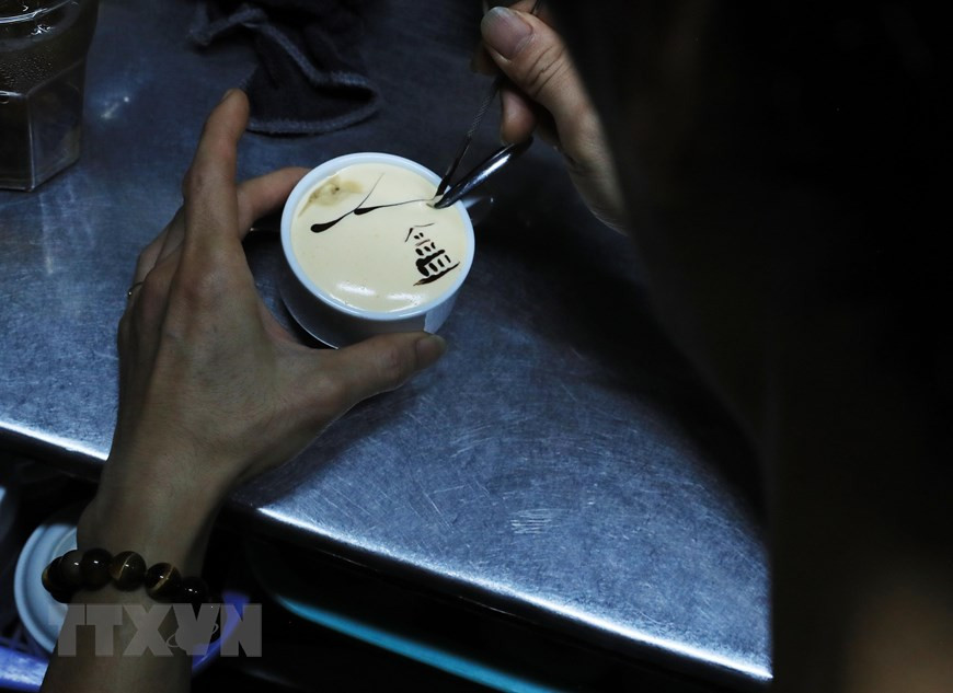 Người pha chế trang trí ly cà phê trứng với hình ảnh Tháp Rùa. (Ảnh: Lâm Khánh/TTXVN) Người pha chế trang trí ly cà phê trứng với hình ảnh Tháp Rùa. (Ảnh: Lâm Khánh/TTXVN)