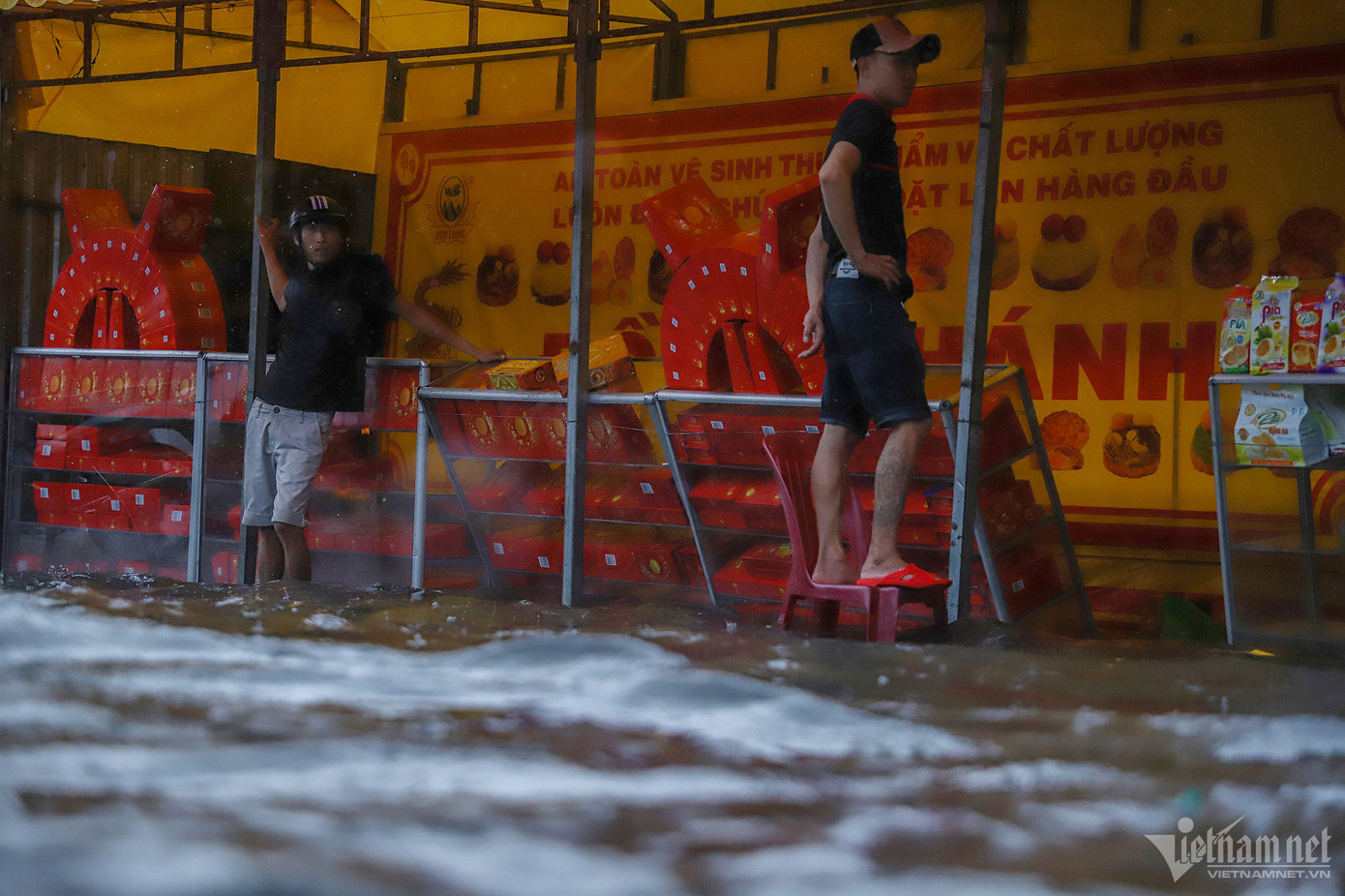 Nước ngập sâu ở quầy bán bánh Trung thu của một nhóm tiểu thương trên đường Nguyễn Duy Trinh. Họ phải kê cao tủ để bánh không bị hư hỏng.