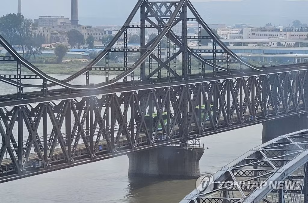 Hai chiếc xe đi từ Triều Tiên vào Trung Quốc. Ảnh: Yonhap