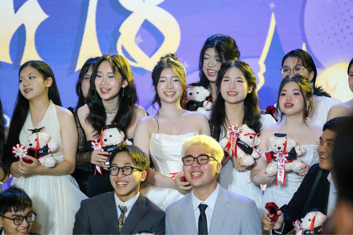 Teen khối 12 hào hứng nhận kỷ niệm chương và gấu tốt nghiệp từ thầy cô và bố mẹ.