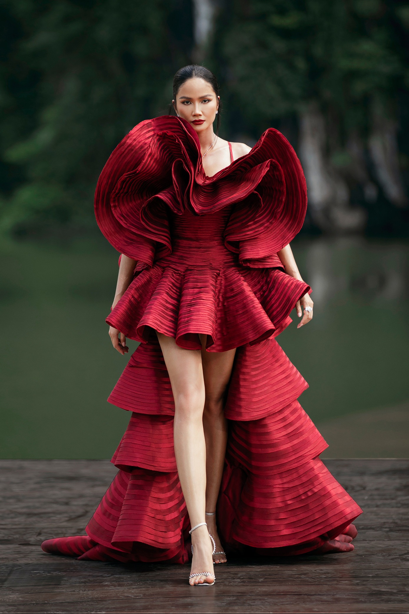 H'Hen Niê mở màn chương trình với bộ váy đỏ tạo dáng 3D lạ mắt, khoe chân dài thon thả.