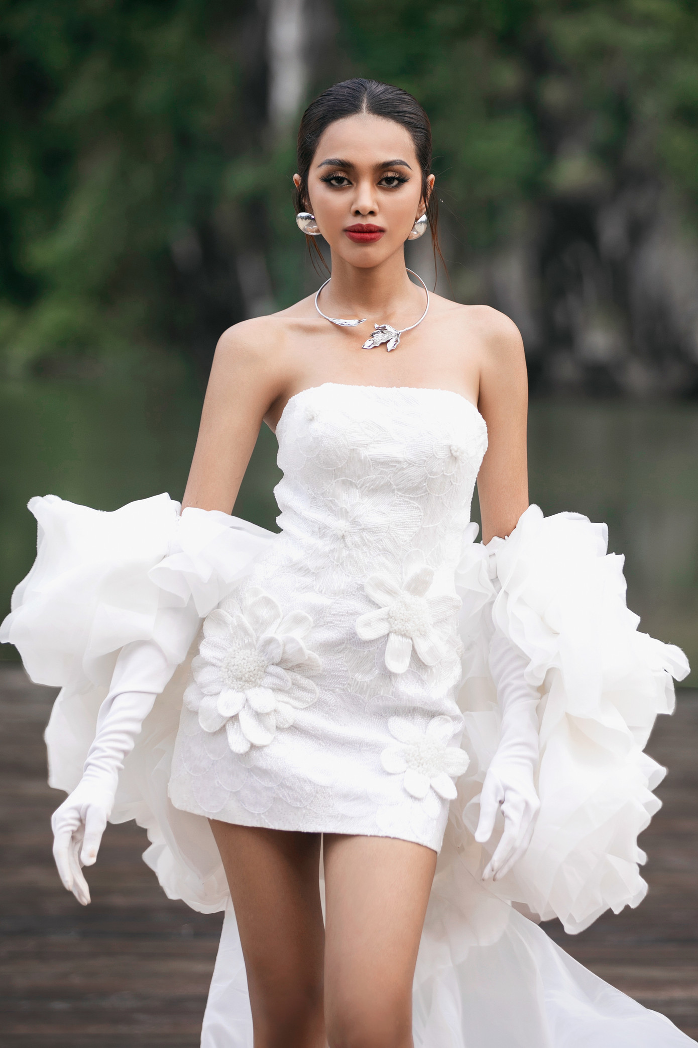 Đại diện Campuchia - Leakena In gây ấn tượng khi trình diễn thiết kế cúp ngực màu trắng được đính kết hoa cầu kỳ dọc thân váy. Cô là Á hậu 2 tại Hoa hậu Hòa bình Campuchia 2023. Leakena In được fan Việt biết đến và yêu mến khi đăng tải clip hát theo ca khúc Em là con gái miền Tây. Người đẹp từng đại diện Campuchia tham dự Hoa hậu Siêu quốc gia 2022 nhưng không giành thành tích.