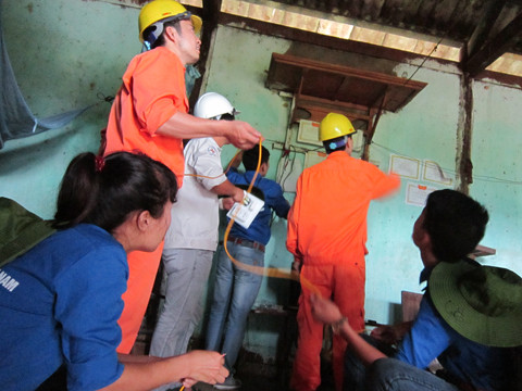 Sinh viên ĐH Điện lực cùng nhân viên Điện lực Lai Châu sửa điện cho một gia đình 