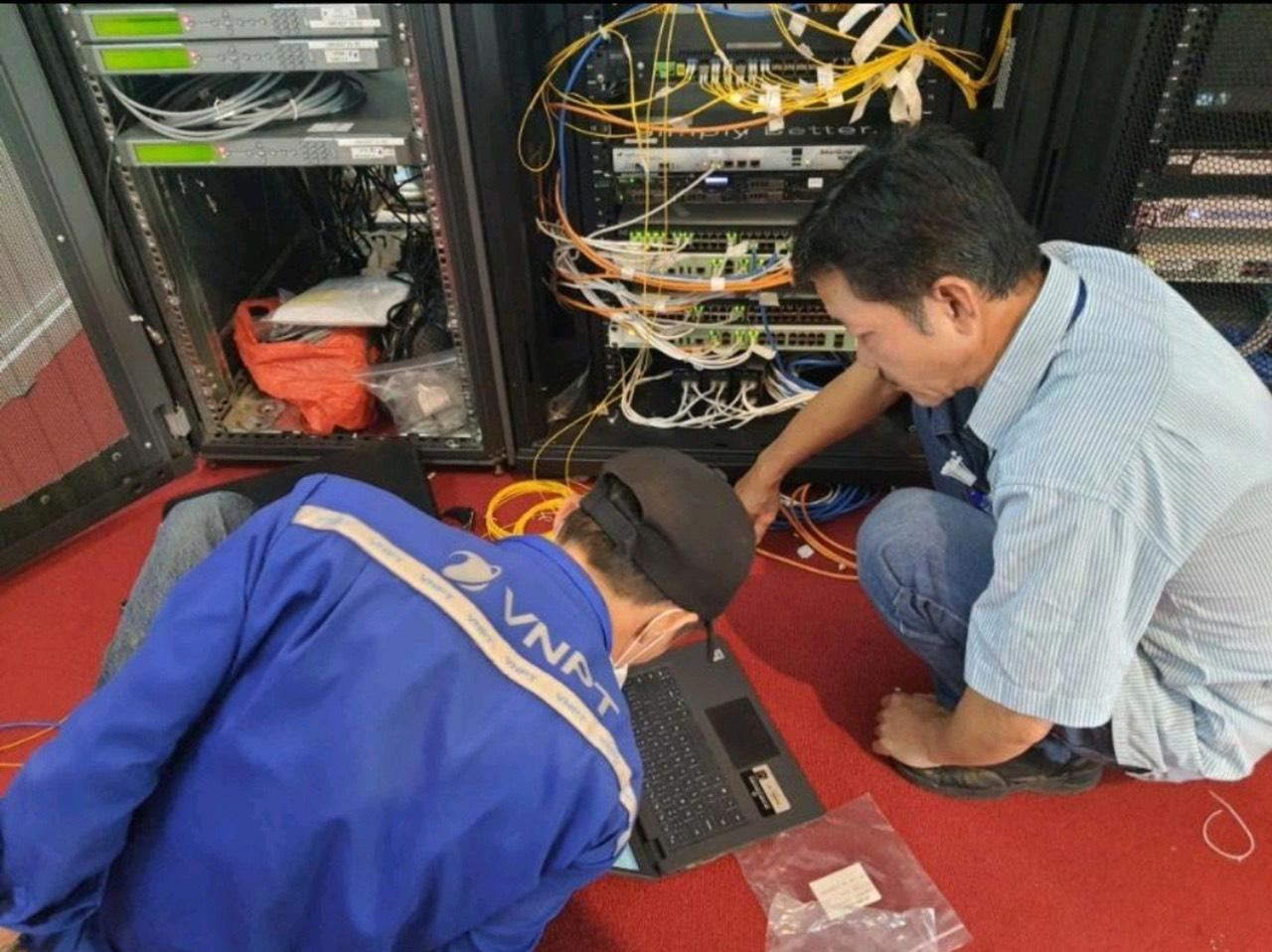 Anh Nguyễn Huy Ánh (Bên phải) và đồng nghiệp thực hiện đấu nối đường Internet đi Quốc tế tại TTHNQG