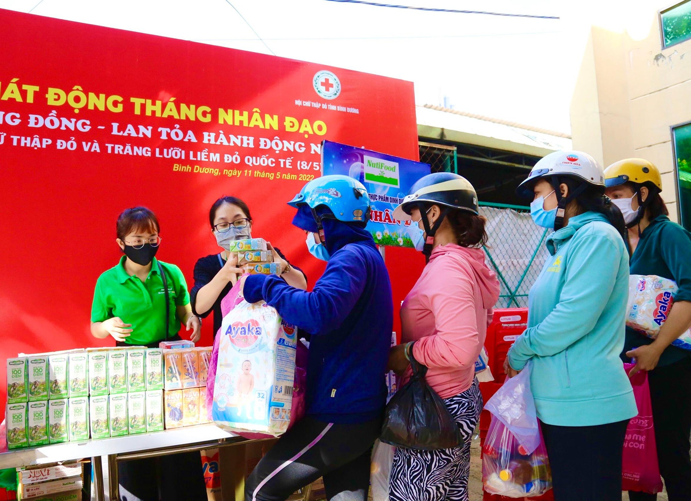 Người dân xếp hàng nhận sữa từ Nutifood tại “Chợ 0 đồng” do Hội Chữ Thập đỏ tỉnh Bình Dương tổ chức