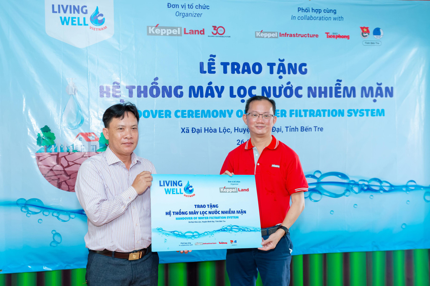 Ông Joseph Low, Chủ tịch Keppel Land Việt Nam (phải) trao tặng hệ thống máy lọc nước nhiễm mặn cho Ông Trương Công Lý (trái), Chủ tịch UBND xã Đại Hòa Lộc