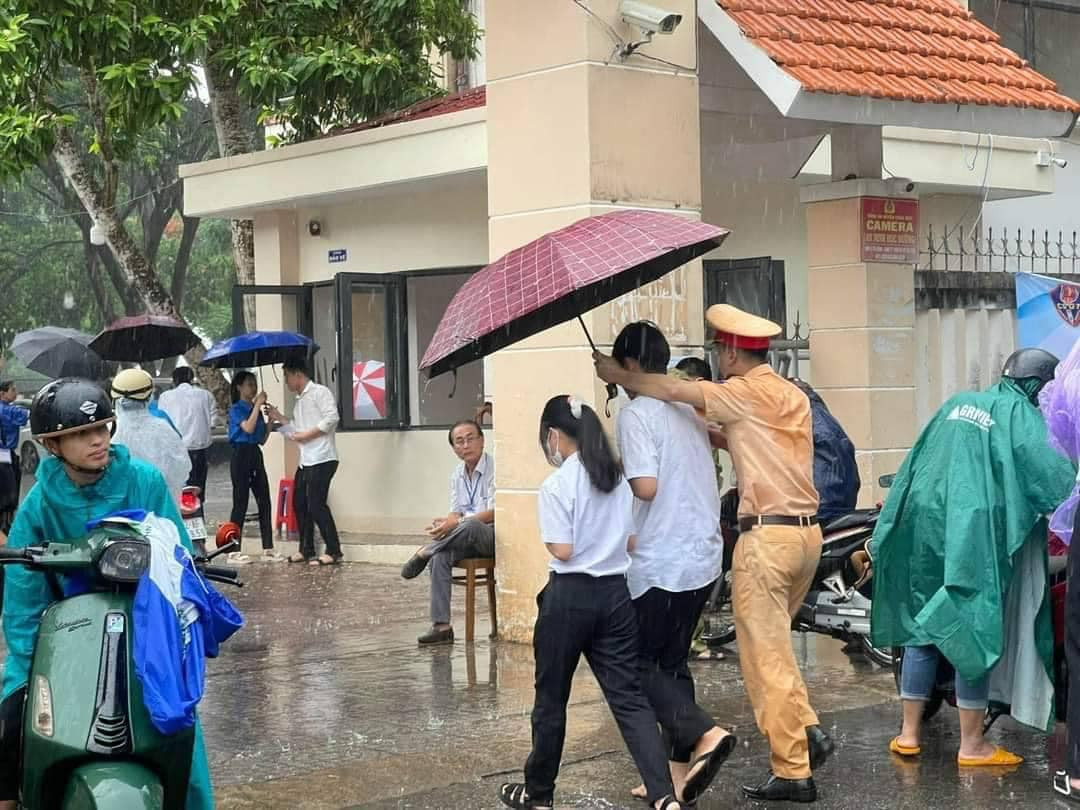 Nhiều chiến sĩ không ngại ướt mưa để đảm bảo thí sinh được khô ráo. Ảnh: Nguyễn Mệt. Nhiều chiến sĩ không ngại ướt mưa để đảm bảo thí sinh được khô ráo. Ảnh: Nguyễn Mệt.