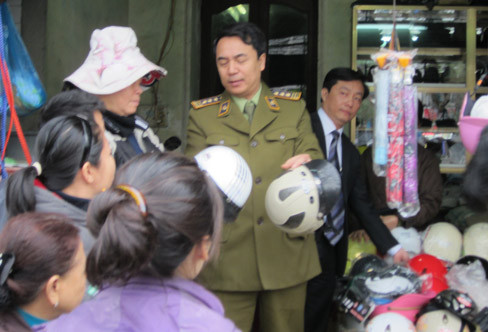 Ông Trần Hùng, Phó Cục trưởng Cục Quản lý thị trường trực tiếp giải thích cho người dân về mũ bảo hiểm không đạt chất lượng. Ảnh: V.S. Ông Trần Hùng, Phó Cục trưởng Cục Quản lý thị trường trực tiếp giải thích cho người dân về mũ bảo hiểm không đạt chất lượng. Ảnh: V.S