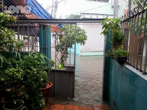 Nước lênh đênh chực tràn vào nhà ở quận 4. Ảnh: Jessica