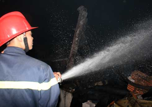 Cảnh sát phun vòi rồng dập tắt đám cháy. Ảnh: Bá Đô. Cảnh sát phun vòi rồng dập tắt đám cháy. Ảnh: Bá Đô