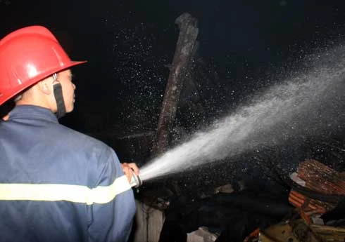 Cảnh sát phun vòi rồng dập tắt đám cháy. Ảnh: Bá Đô